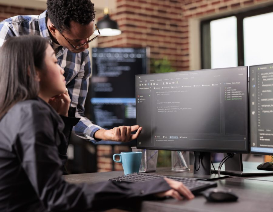 diverse-programmers-discussing-about-html-code-compiling-discovers-errors-standing-front-multiple-screens-startup-office-software-developers-working-server-interface-development
